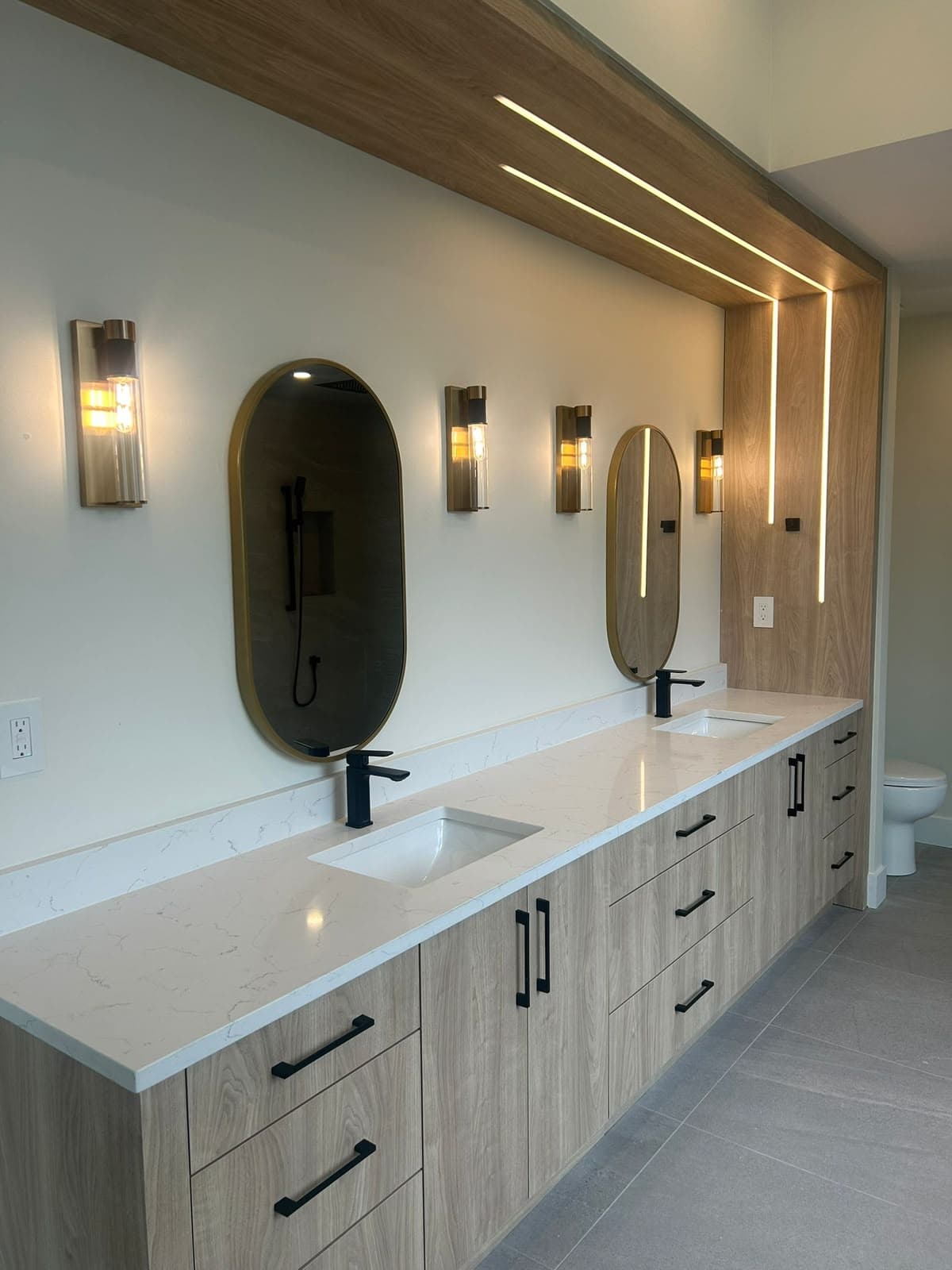 Double vanity bathroom renovation with two undermount sinks and matte black faucets